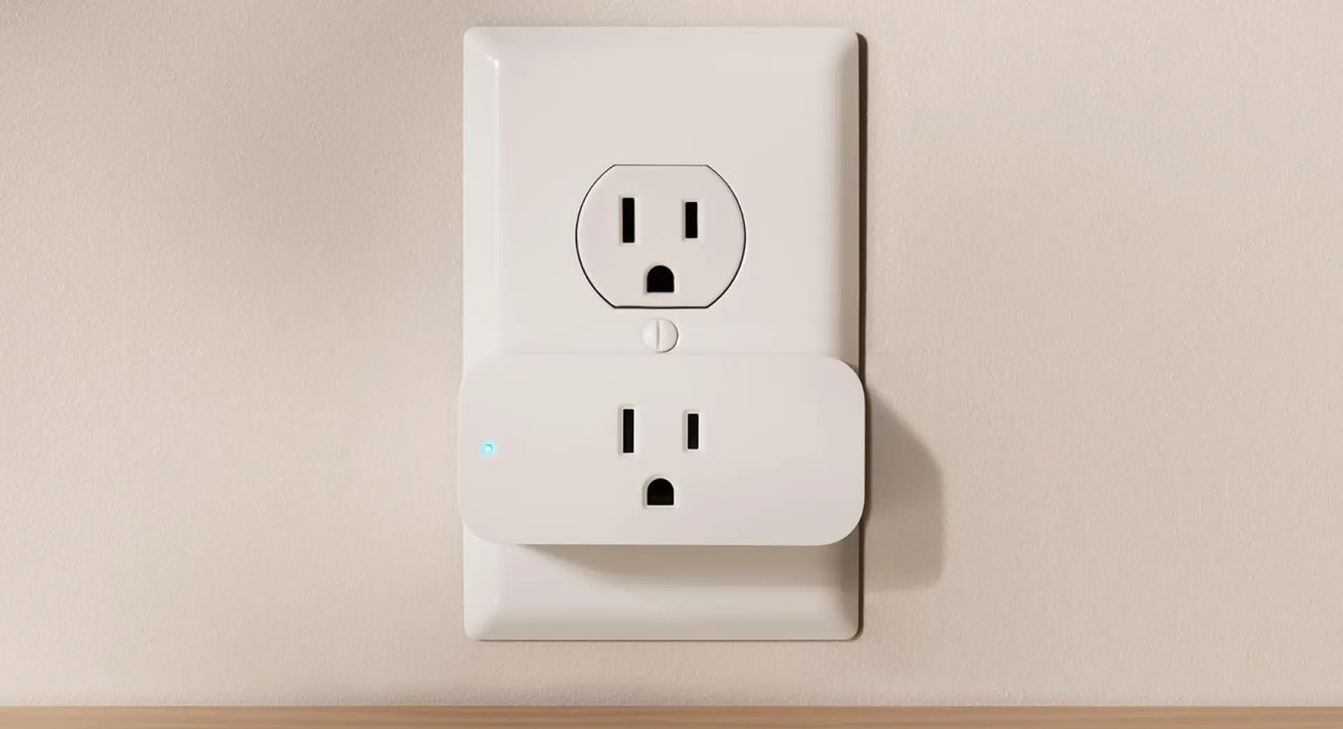 Amazon Smart Plug installed in a U.S. wall outlet—compact white 15-amp Wi-Fi smart socket with Alexa voice control, leaves top receptacle free for other devices